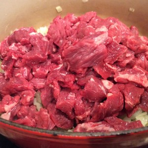 Beef added to the onions in the pot
